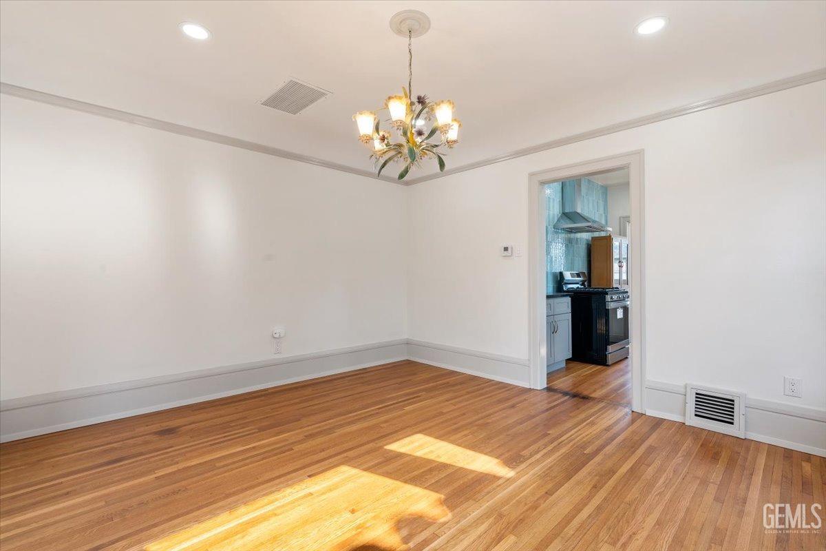 Undisclosed Address Bakersfield, CA 93305 - Photo 13 of 49 a view of a room with wooden floor and chandelier