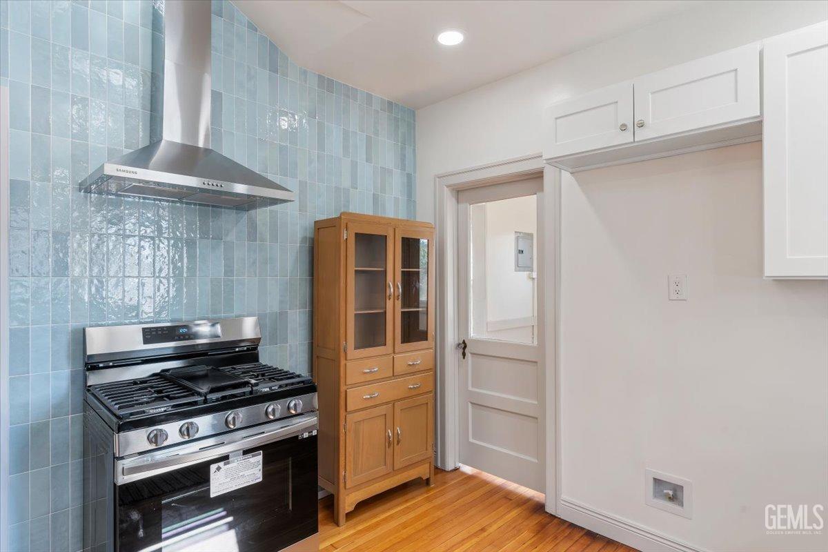 Undisclosed Address Bakersfield, CA 93305 - Photo 16 of 49 a kitchen with wooden floor and a stove top oven