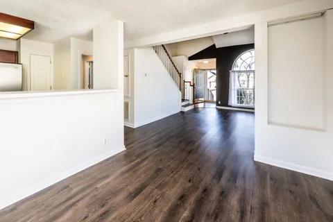 a view of a living room with wooden floor and a window