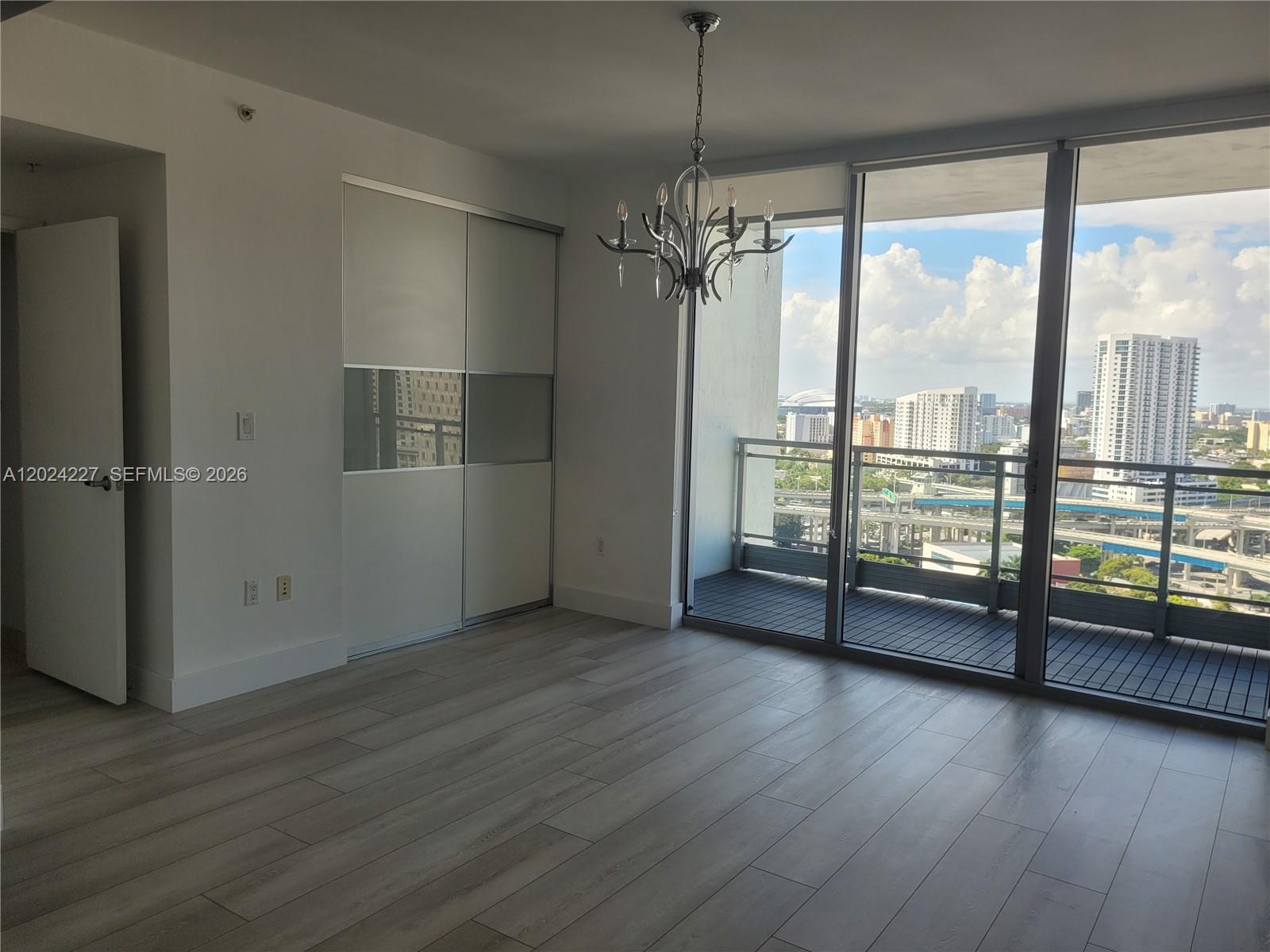 90 Southwest 3rd Street, Unit 2208 Miami, FL 33130 - Photo 16 of 56 an empty room with wooden floor fan and windows