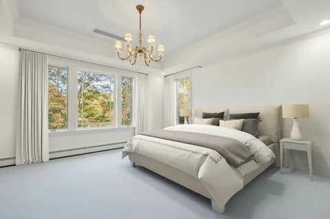 a spacious bedroom with a bed and a chandelier