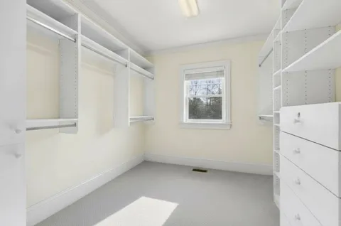 a view of a kitchen with refrigerator and white cabinets