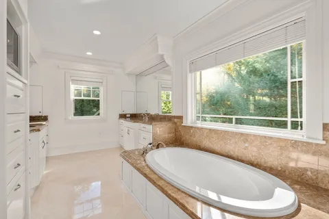a bath tub sitting in a bathroom next to a window