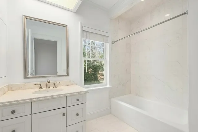 a bathroom with a tub a sink and a window