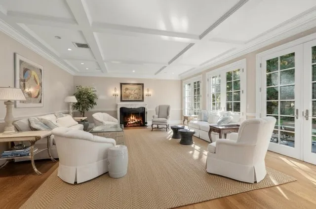 a living room with fireplace furniture and a large window