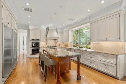 a kitchen with stainless steel appliances kitchen island granite countertop a refrigerator and cabinets