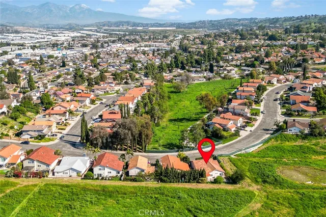 an aerial view of residential houses with outdoor space and trees