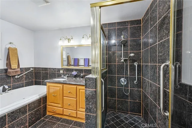 a bathroom with a granite countertop sink a mirror and shower