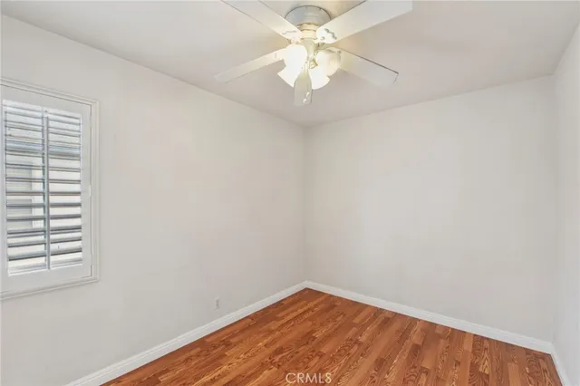 an empty room with a window and a fan