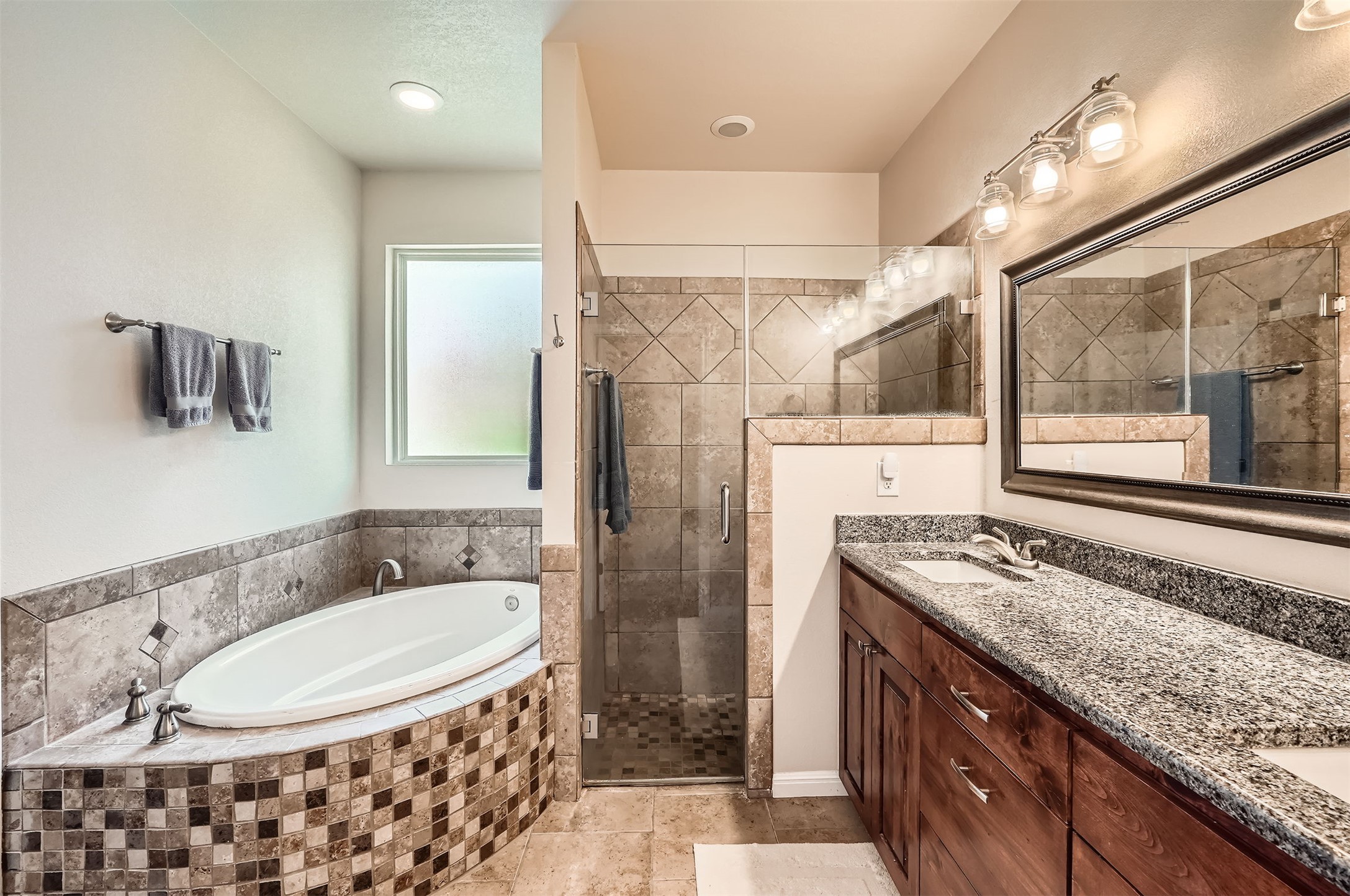 5501 Hitching Post Lago Vista, TX 78645 - Photo 18 of 26 a bathroom with a granite countertop sink a mirror and shower