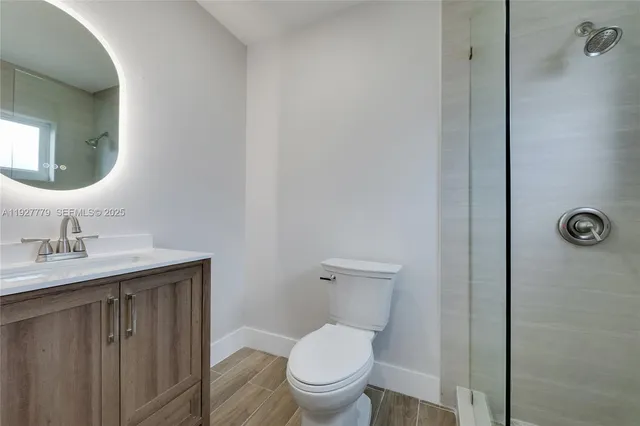 a bathroom with a toilet a sink a mirror and vanity