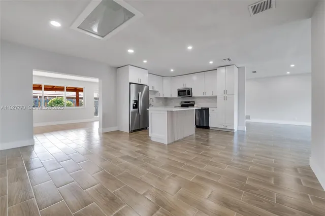 a view of a electric appliances in kitchen and an empty room
