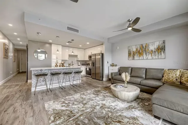 a living room with furniture a rug and kitchen view