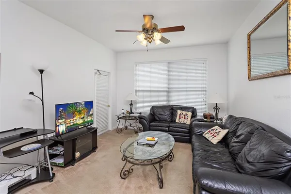 a living room with furniture a ceiling fan and a window
