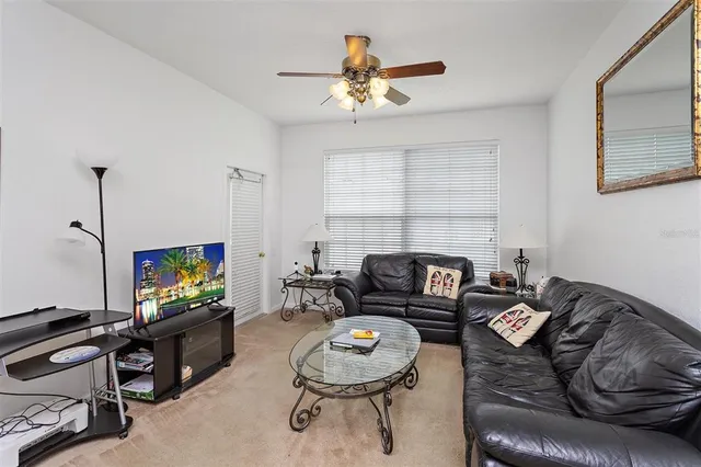 a living room with furniture a ceiling fan and a window