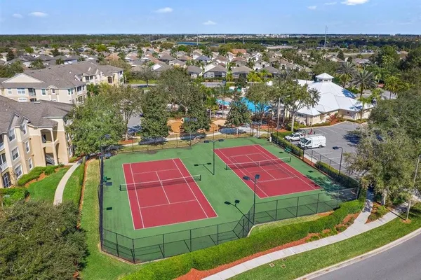a tennis court that has houses in the background