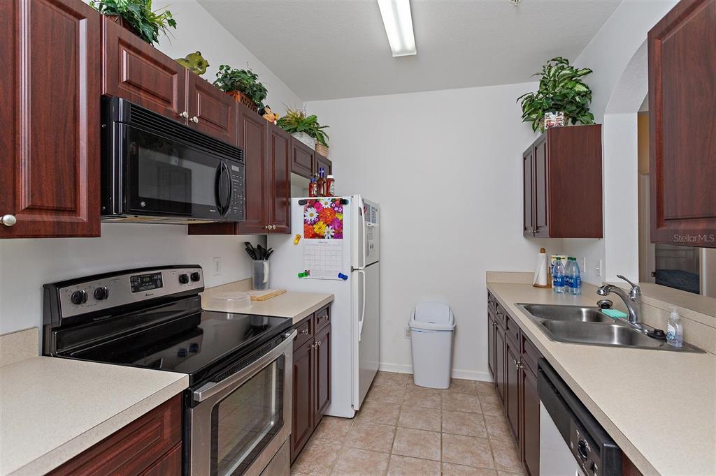 2307 Silver Palm Drive, Unit 202 Kissimmee, FL 34747 - Photo 6 of 34 a kitchen with a sink stove and microwave
