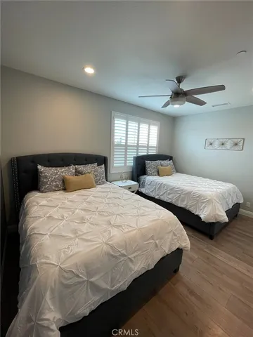 a bedroom with two beds and a ceiling fan