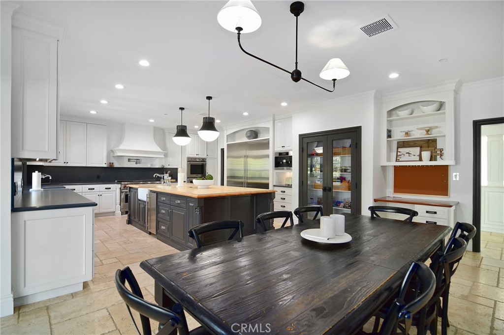 4947 Summit View Drive Westlake Village, CA 91362 - Photo 16 of 61 a kitchen with a dining table chairs stainless steel appliances and cabinets