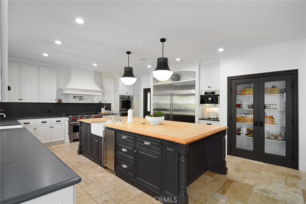 4947 Summit View Drive Westlake Village, CA 91362 - Photo 52 of 61 a large kitchen with stainless steel appliances a stove a sink dishwasher and a refrigerator with wooden floor