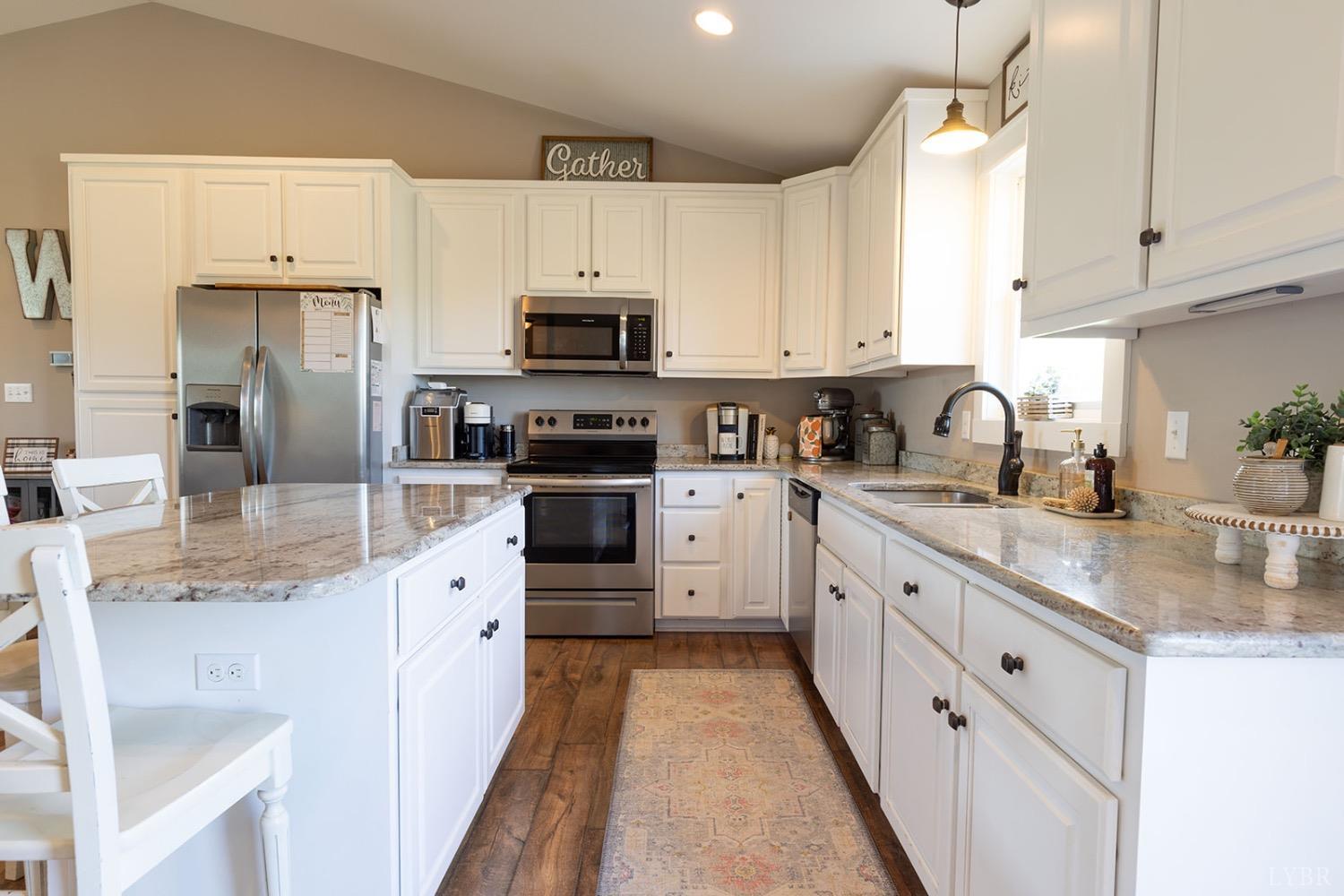 2490 Red House Road Rustburg, VA 24588 - Photo 13 of 33 a kitchen with stainless steel appliances granite countertop a sink dishwasher a refrigerator and white cabinets with wooden floor