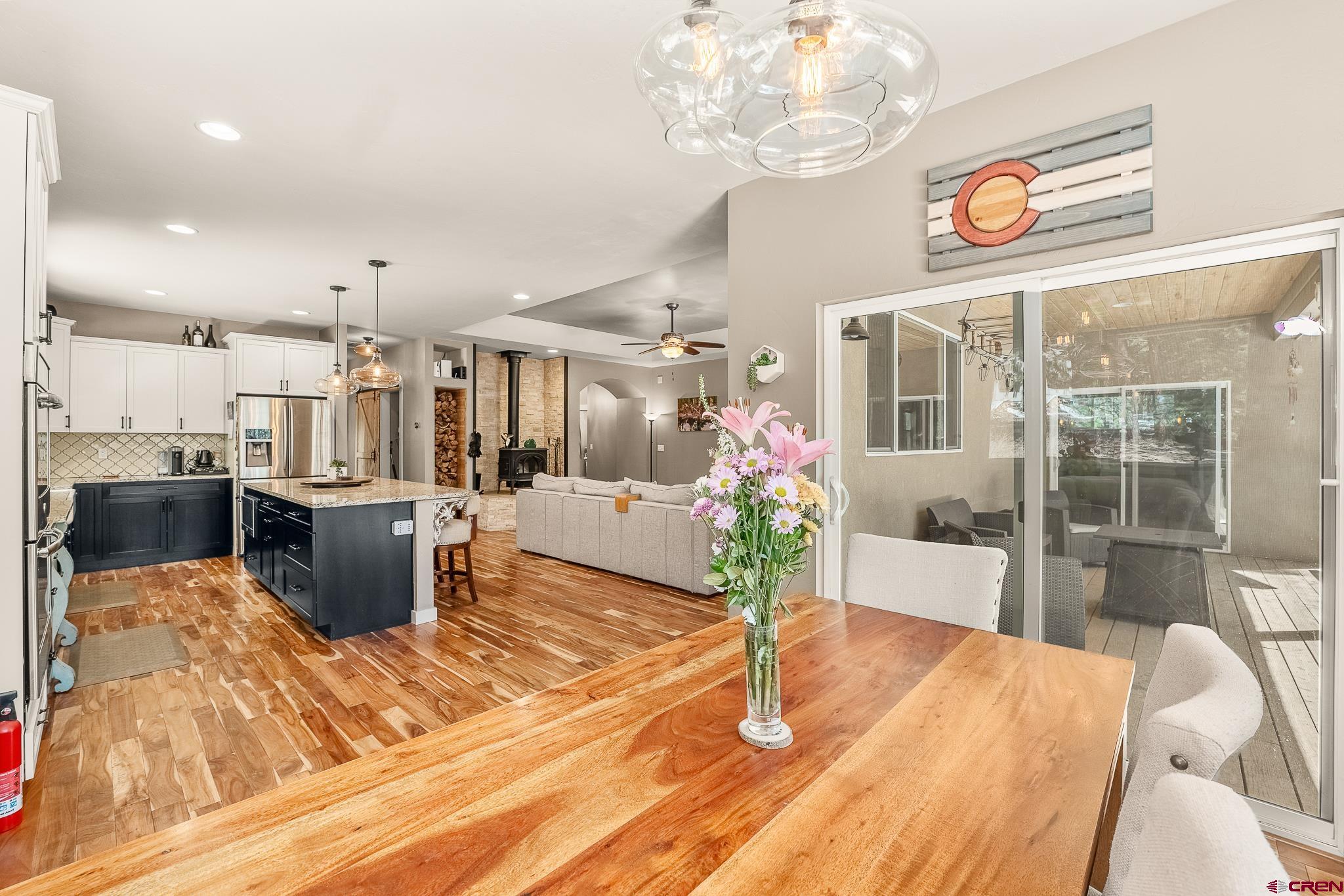 671 Sierra Circle Durango, CO 81301 - Photo 19 of 35 a dining room with wooden floor a chandelier a wooden table and chairs