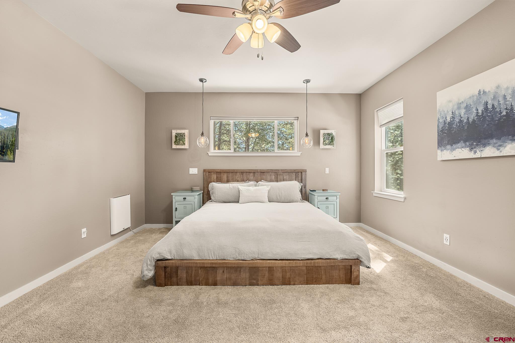 671 Sierra Circle Durango, CO 81301 - Photo 20 of 35 a spacious bedroom with a bed and a painting on the wall