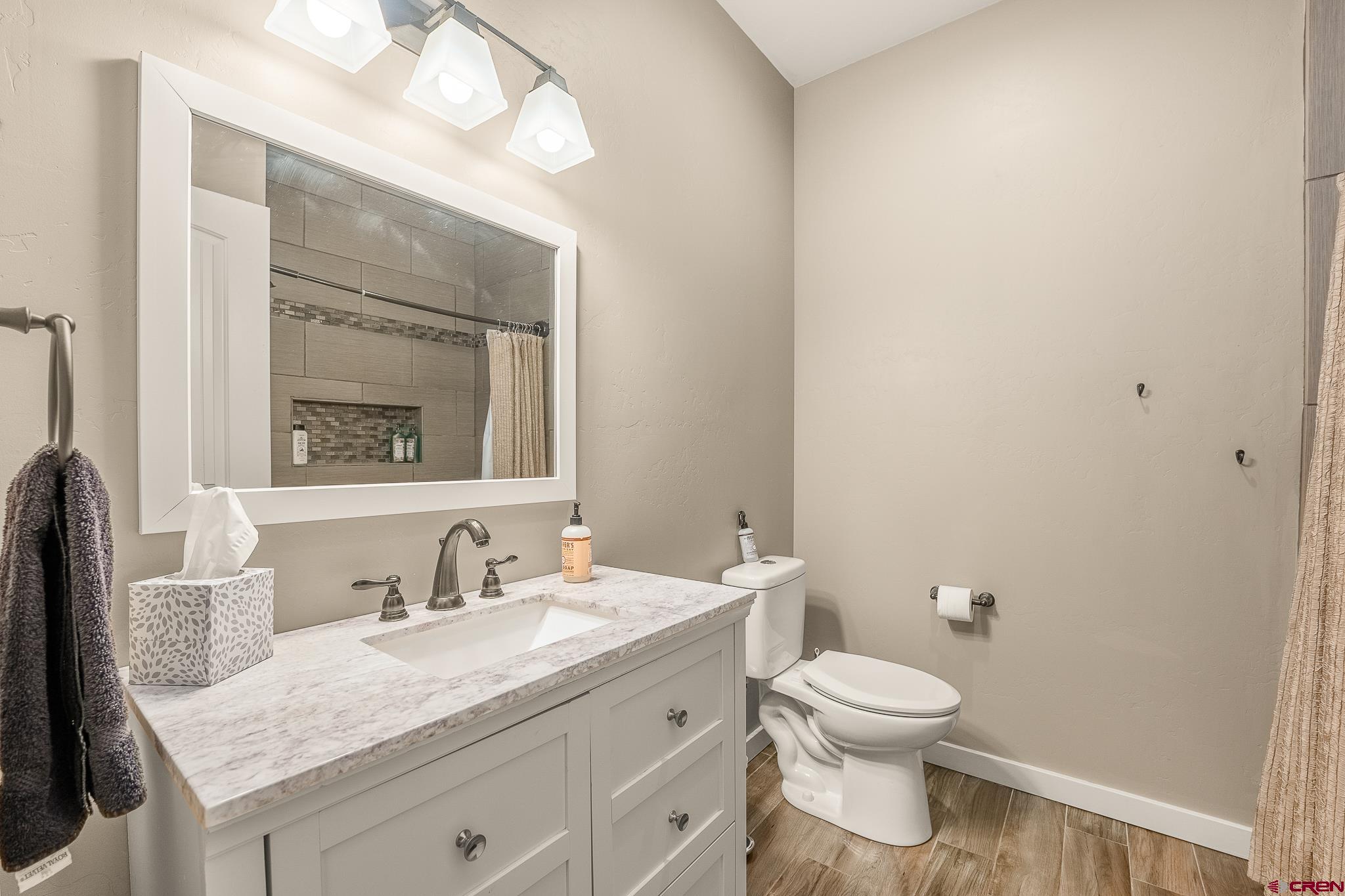 671 Sierra Circle Durango, CO 81301 - Photo 28 of 35 a bathroom with a granite countertop toilet a sink and a mirror