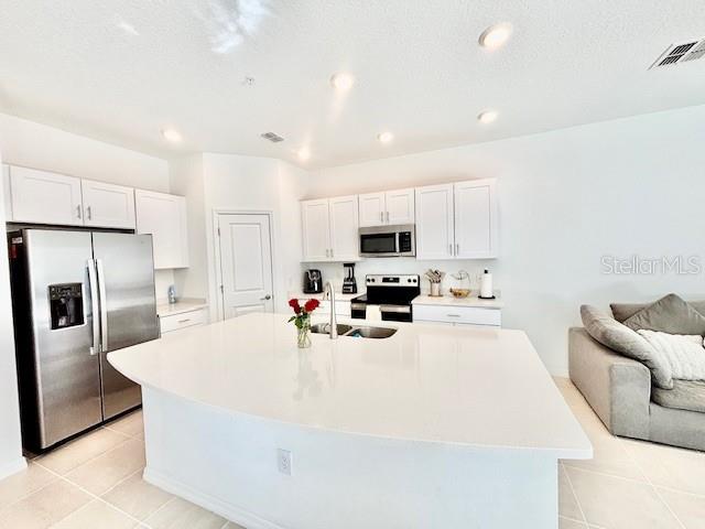 4520 Calvary Way St. Cloud, FL 34769 - Photo 3 of 9 a kitchen with stainless steel appliances a refrigerator sink stove microwave and cabinets