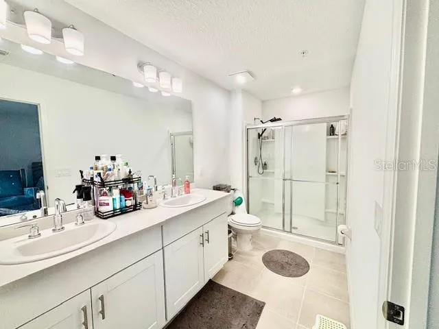 a bathroom with a granite countertop sink mirror vanity and toilet