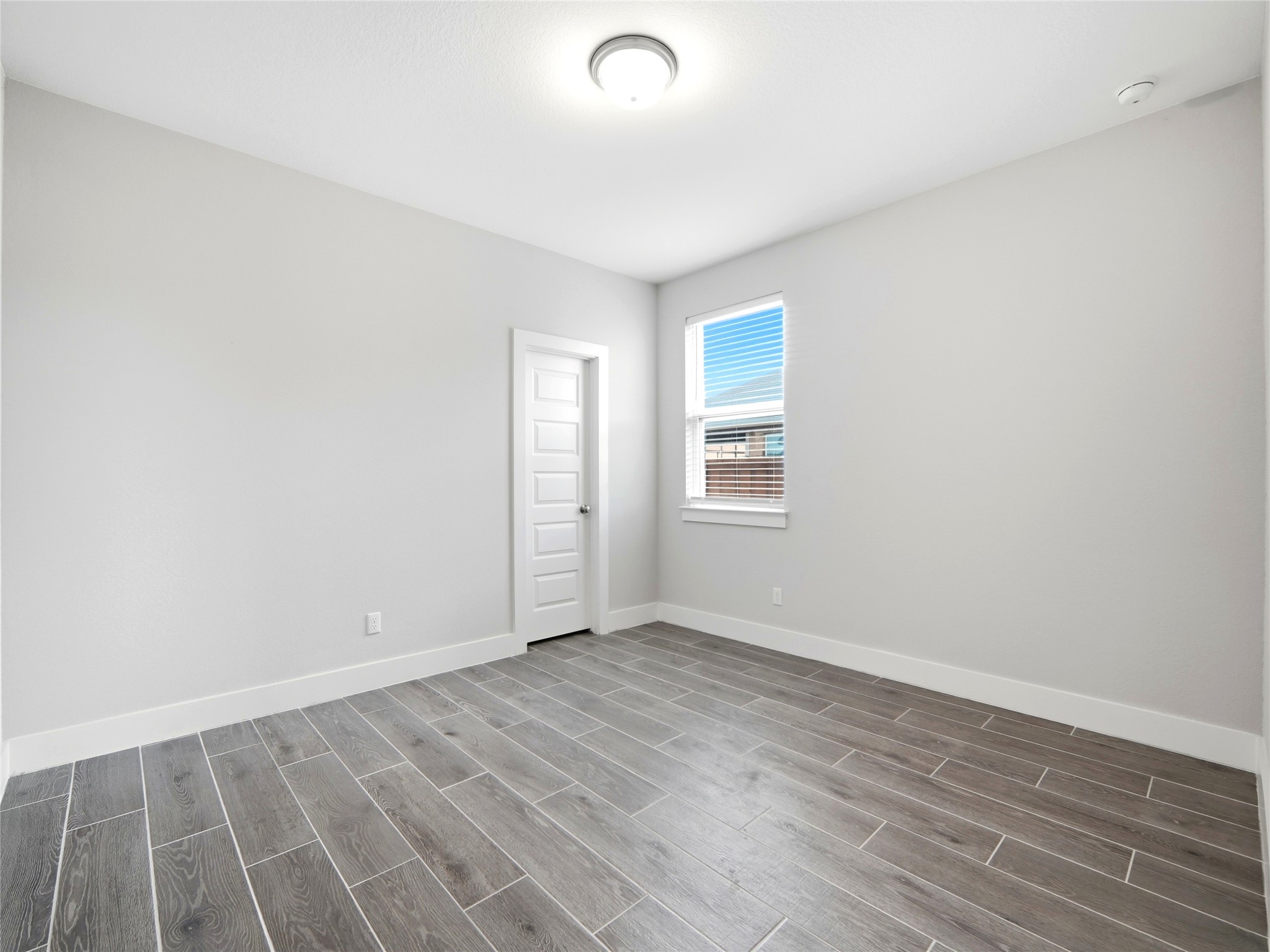 848 Wild Pecan Loop Buda, TX 78610 - Photo 12 of 49 Bright and inviting bedroom with modern wood-look flooring and ample natural light.