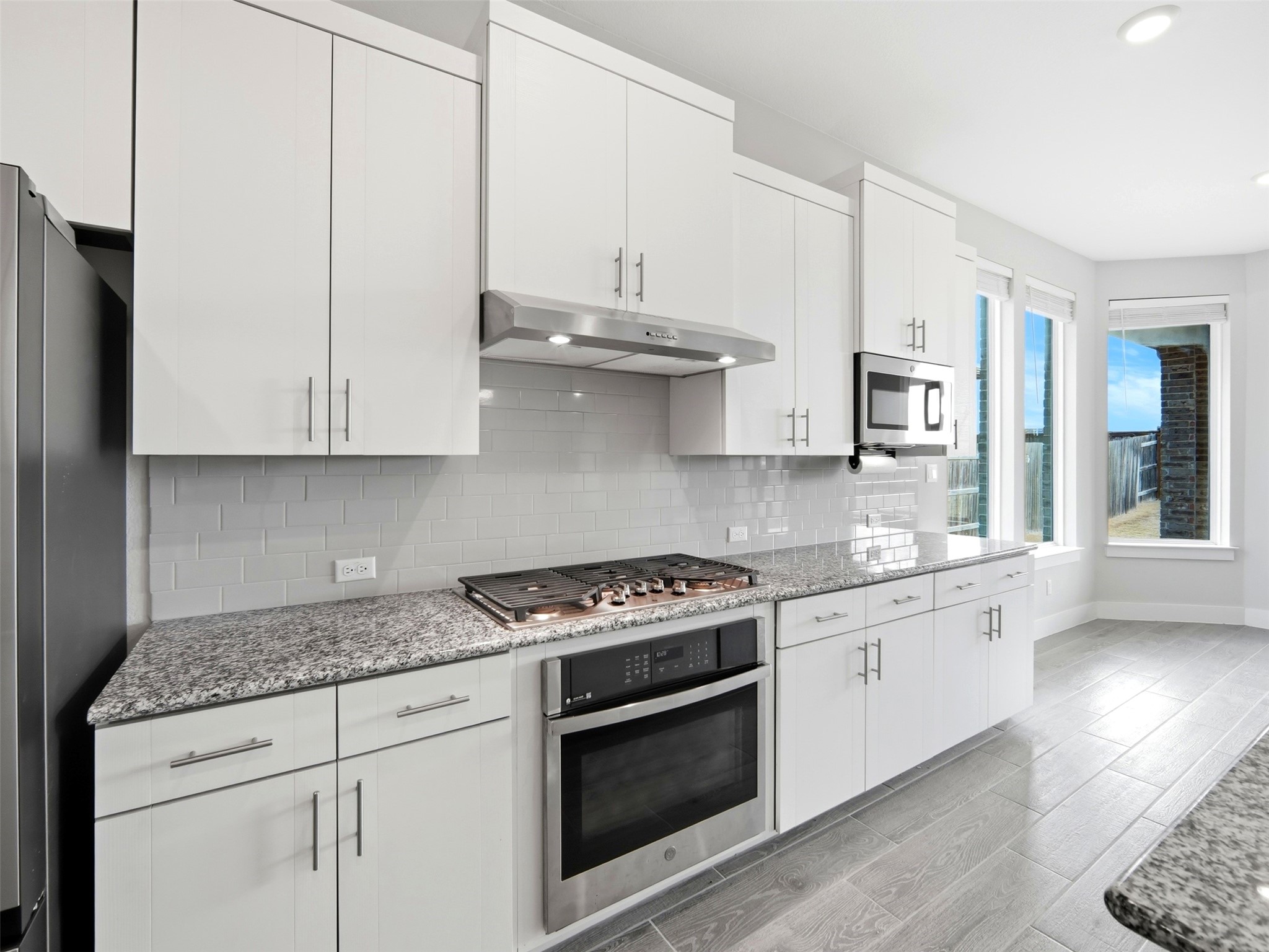 848 Wild Pecan Loop Buda, TX 78610 - Photo 31 of 49 Modern kitchen featuring a gas stovetop, smart oven, illuminated vent, and built-in microwave.