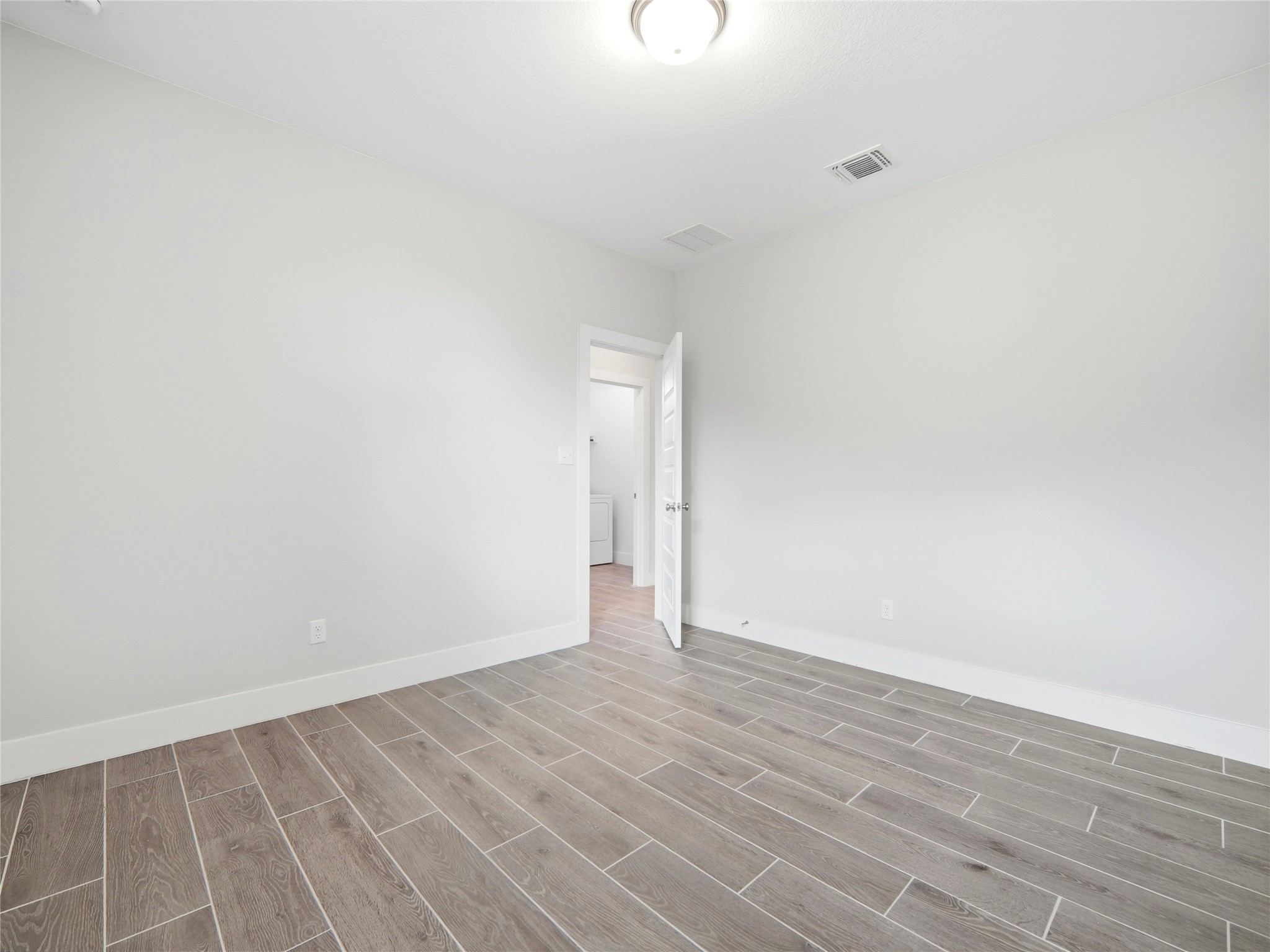 848 Wild Pecan Loop Buda, TX 78610 - Photo 10 of 49 This inviting bedroom features a neutral palette and elegant wood-style flooring, offering a serene space ready for your personal touch.