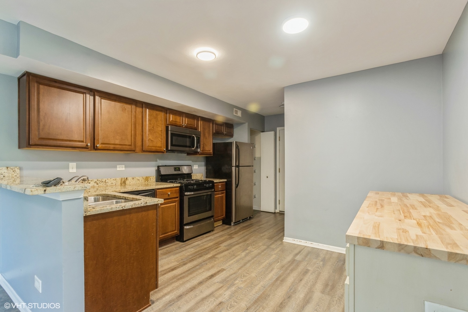 3022 Anton Drive Aurora, IL 60504 - Photo 5 of 15 a kitchen with stainless steel appliances granite countertop a stove top oven a sink dishwasher and a refrigerator with wooden floor