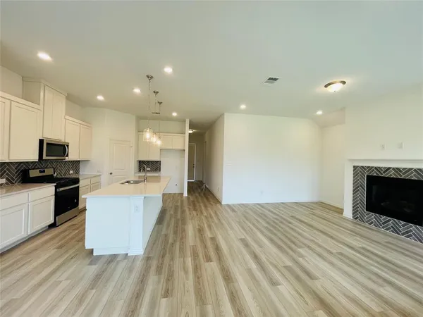 a large kitchen with kitchen island a sink dishwasher a stove and a microwave oven on granite countertops