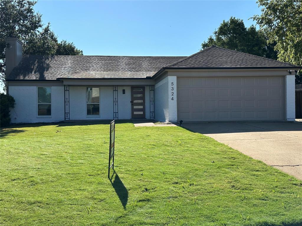 Single story home with a garage and new front lawn