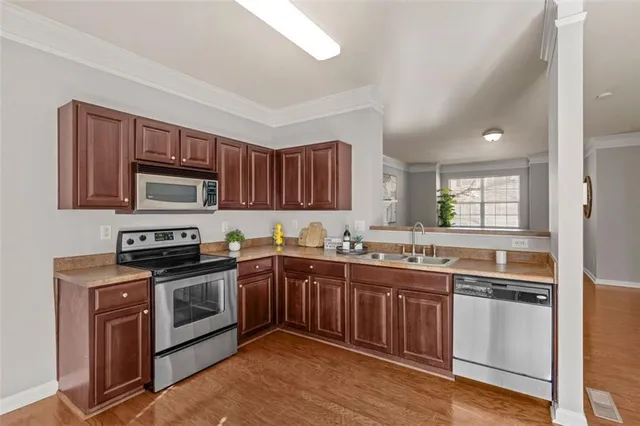 a kitchen with stainless steel appliances granite countertop wooden cabinets and a stove top oven