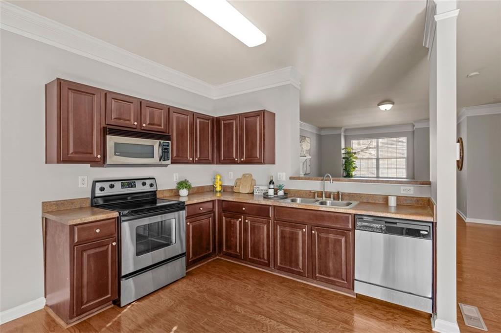 6816 Blackstone Place Mableton, GA 30126 - Photo 11 of 33 a kitchen with stainless steel appliances granite countertop wooden cabinets and a stove top oven