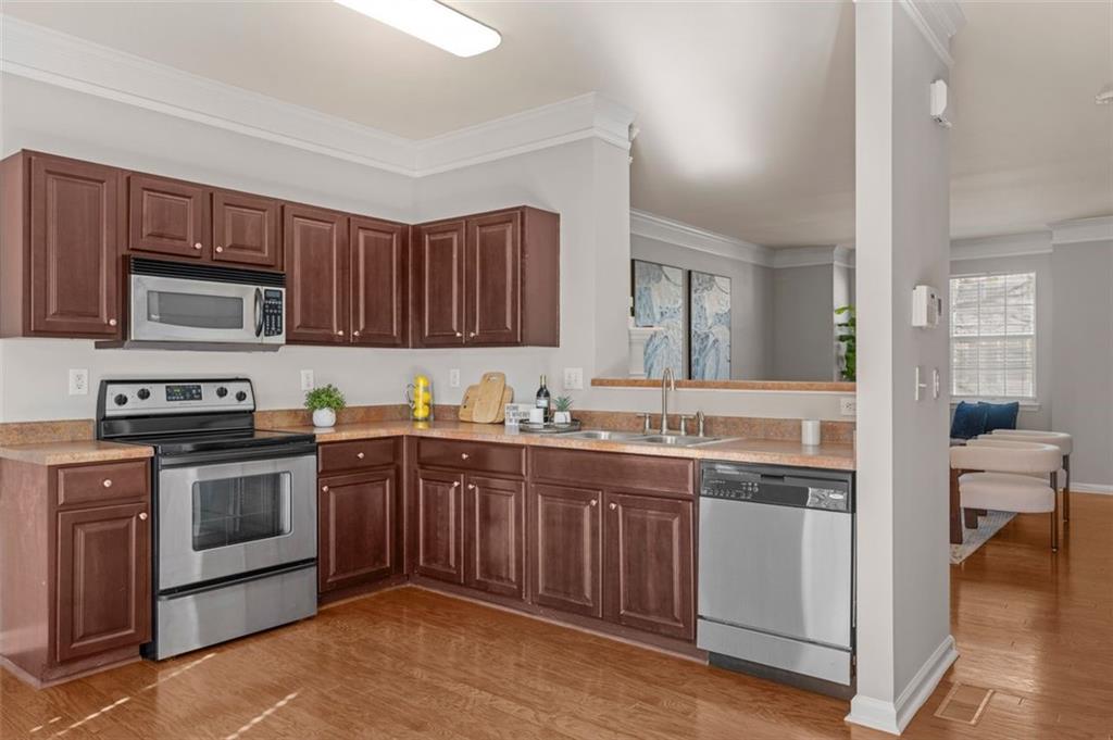 6816 Blackstone Place Mableton, GA 30126 - Photo 14 of 33 a kitchen with stainless steel appliances granite countertop a stove sink and cabinets