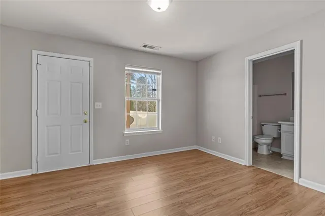 a big room with wooden floor and a bathroom