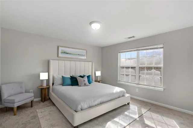 a bedroom with a bed and a large window