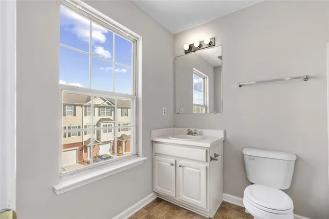 a bathroom with a toilet a sink and a large mirror