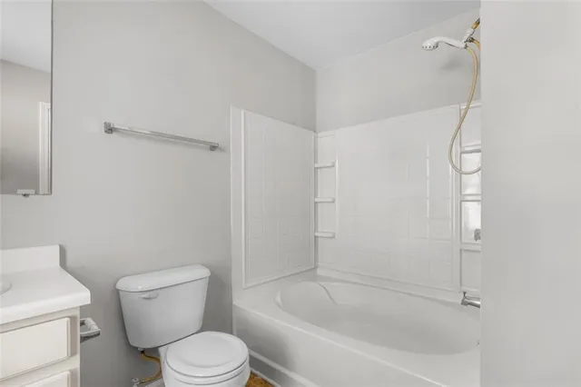 a white toilet sitting next to a bath tub