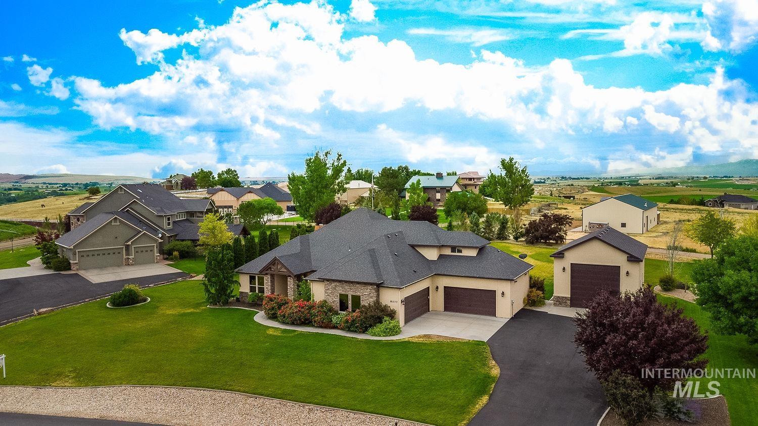 8077 Star Pass Ridge Road Nampa, ID 83686 - Photo 3 of 37 Expansive property featuring a stone and stucco exterior, multiple attached garages, and a detached garage/shop building