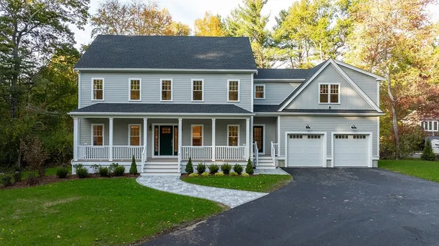 a front view of a house with a yard and trees