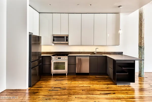 a kitchen with stainless steel appliances granite countertop a stove a sink and a microwave