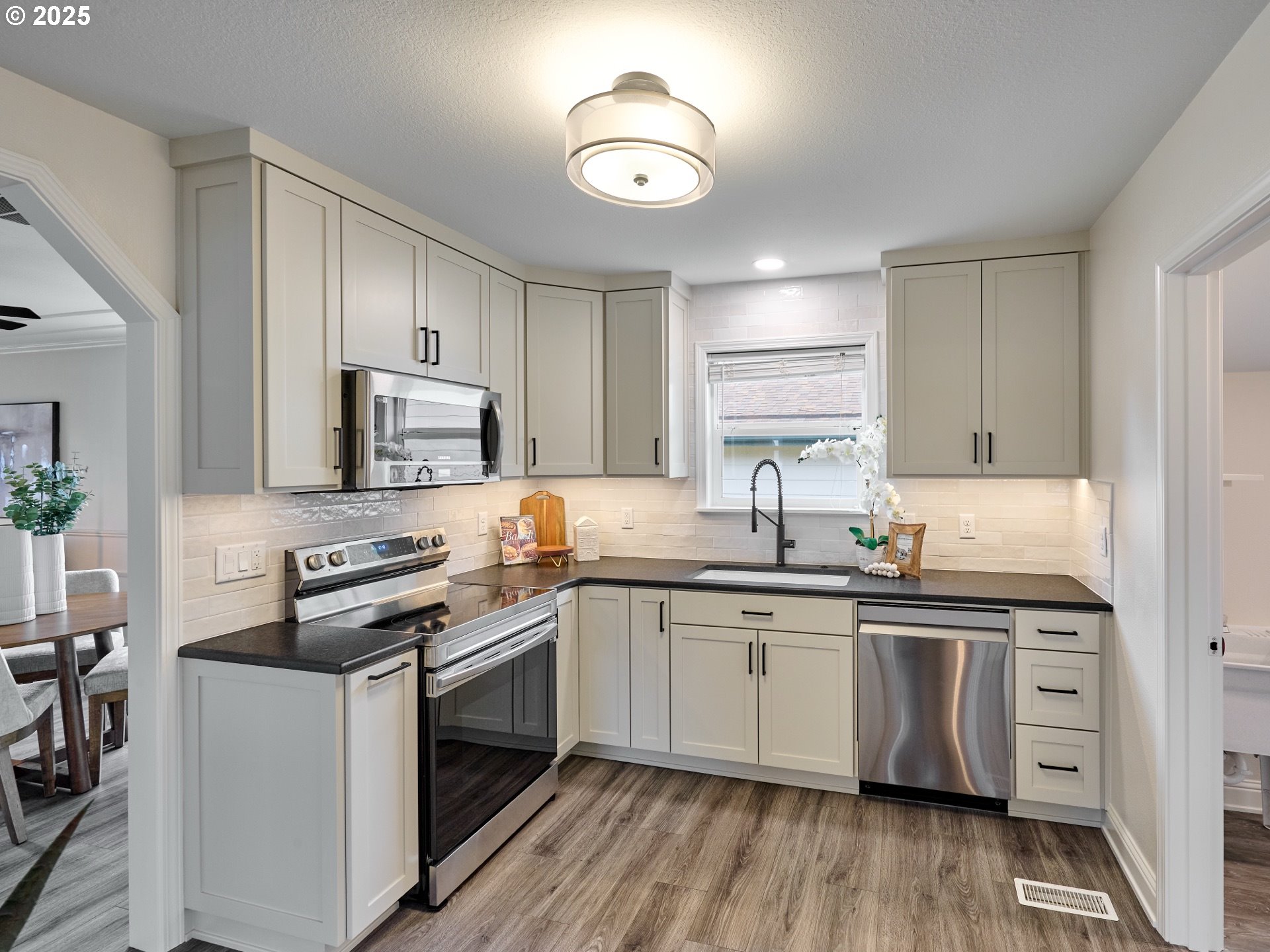 1006 Well Street Silverton, OR 97381 - Photo 10 of 35 a kitchen with stainless steel appliances a sink cabinets and wooden floor