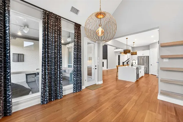 a view of a hallway with wooden floor and furniture