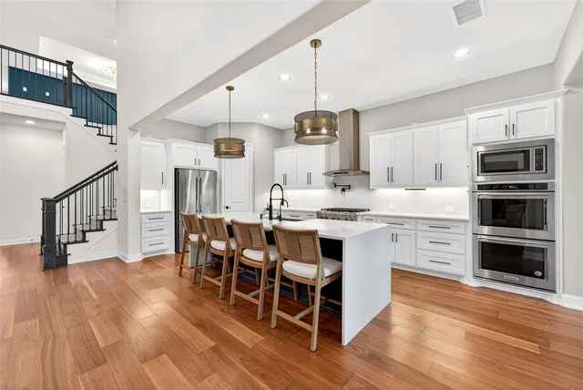 a large white kitchen with wooden floor