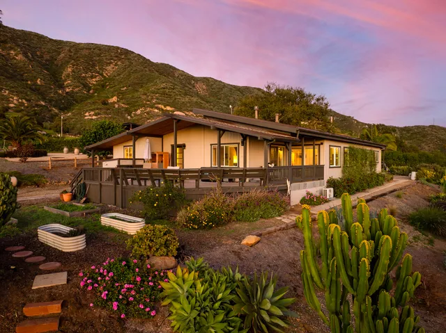 a view of a house with a yard and garden